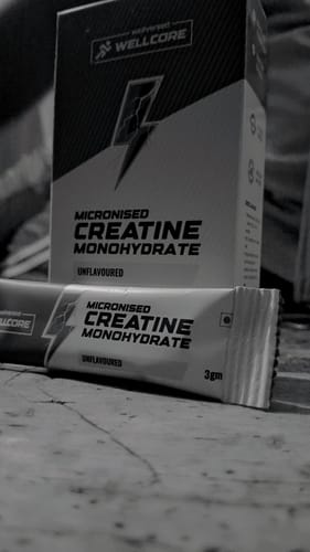 Customer shows a single sachet of Wellcore Micronised Creatine Monohydrate with the product box in the background.