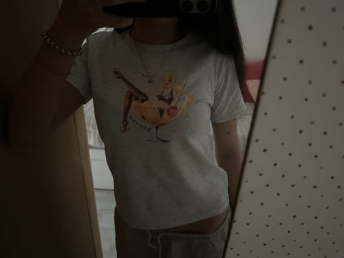 Customer's mirror selfie showing the fit of the grey graphic pin up baby tee.