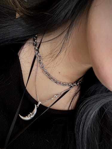A reviewer wears the 6MM MINI ARIES CHAIN layered with a thinner silver necklace against a black top.