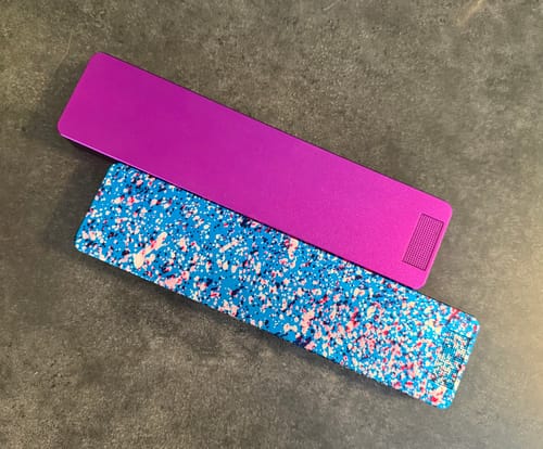 Customer's two Weekly Cases on a dark surface. One case is magenta and the other has a blue splatter pattern.