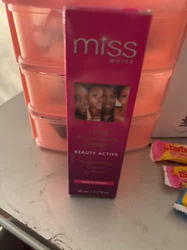 Customer's pink box of Miss White Brightening Cream for Face standing on a counter.