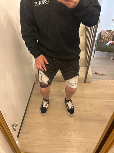 Reviewer showing the black Soldier’s Faith Performance Shorts with a white compression layer and visible cross graphic.