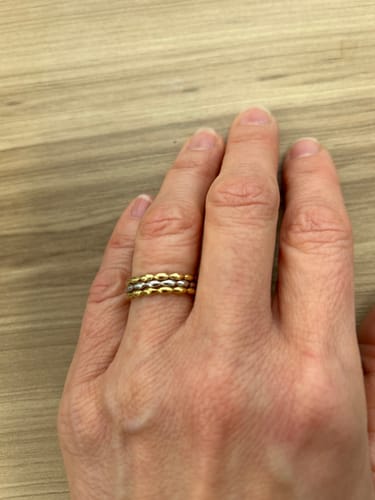 Customer's hand wearing the Two-Tone Eternal Chain Band, showing the alternating gold and silver links on their finger.