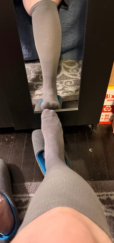 Customer wearing a grey Performance Eucalyptus Compression Sock on one leg, viewed from above with a mirror reflection.