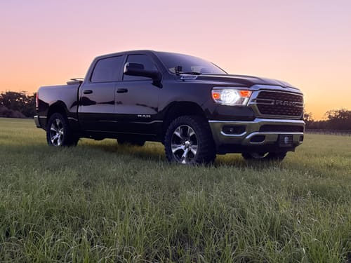 Customer's black Ram 1500 with the 3" Front Leveling Lift Kit, showing a raised stance in a grassy field.