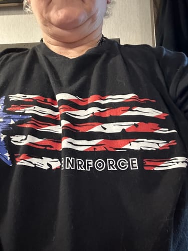 Reviewer shows a close-up of their black Merica Tee, highlighting the distressed flag graphic and ENRFORCE text.