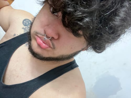 Close-up of a reviewer wearing the silver FAUX SPIKED HEART SEPTUM in their nose.