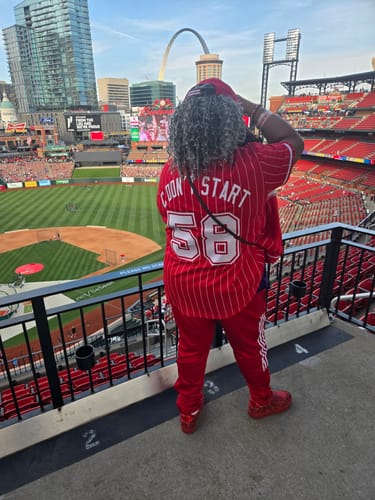 Reviewer from behind wearing the custom red and white pinstripe baseball jersey at a stadium.