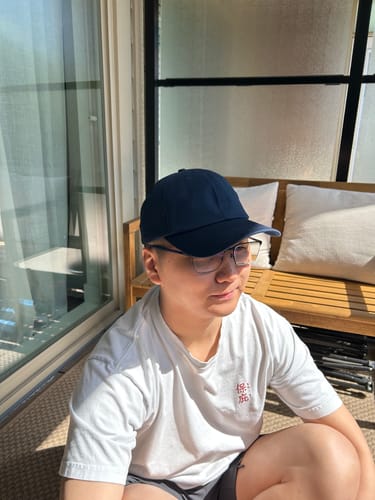 Customer wearing the dark blue Big Dad Hat Washed while sitting outside in the sun.