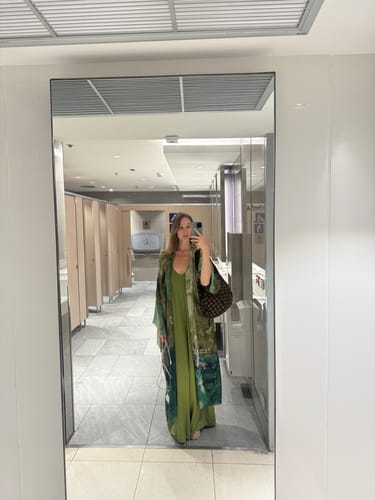 Reviewer's mirror selfie showing the full-length Audrey Satin Jumpsuit in olive green.