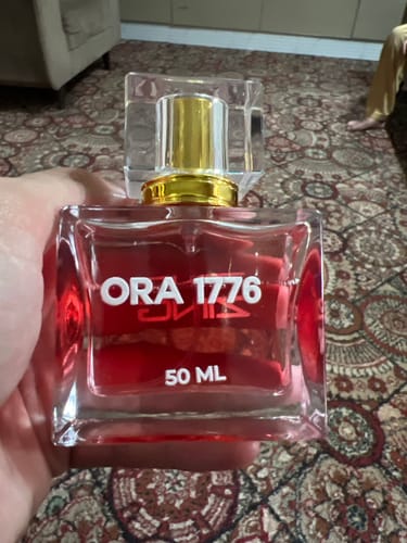 Customer holding their bottle of Ora 1776 fragrance from the OUD Supreme Bundle.