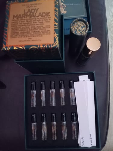 Customer's unboxed Discovery Set showing small sample vials in a green box, with blotters and other perfume packaging nearby.