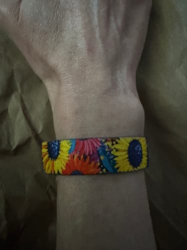 Customer wearing the colorful Bloom Anyway Bracelet on their wrist, showing the detailed floral design.