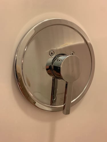Close-up of the customer's polished chrome shower valve kit installed on a shower wall.