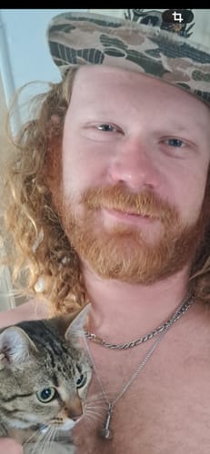A reviewer wearing the Hammer of Strength Urn Pendant on a thin chain necklace.