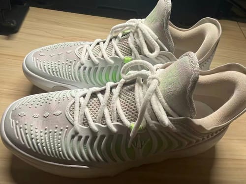 Reviewer's pair of white and green Joker 2 GT "MIRO" shoes sitting on a wooden surface.