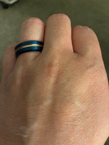 Customer wearing the Caelum ring, showing its deep blue band with a refined rose gold stripe.