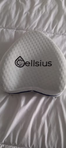 Le coussin orthopédique Cellsius d'un client, posé sur une literie blanche.