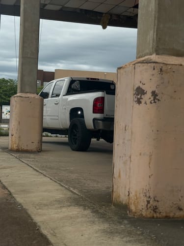 Partial view of a customer's white truck showing the GFP Premium Decal on the back window.