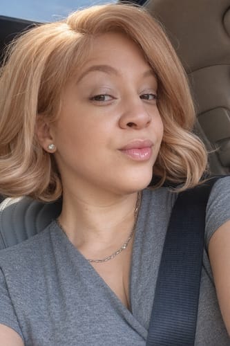 Reviewer wearing the Sensationnel Butta Lace Chic Bob Wig in a stylish peach blonde color with curled ends.