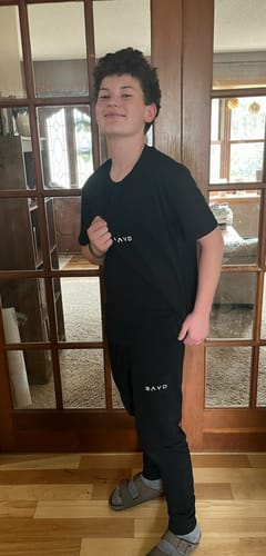 Customer showing a person wearing a black matching set and the product socks indoors.