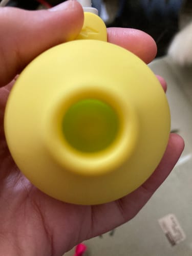 Customer holding the yellow Lem massager, showing a close-up of the suction opening.
