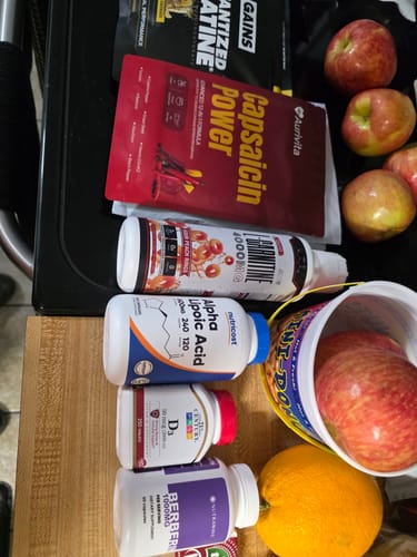 Customer's Liquid L-Carnitine 4000MG bottle shown with other workout supplements and some fresh fruit on a counter.