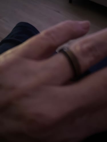 Close-up: Blurry image of a customer wearing the black Horizon ring with a rose gold groove.