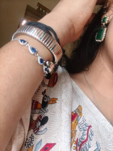 Customer wearing the Silver Royal Blue Drop Bracelet on their wrist, styled with other jewelry.