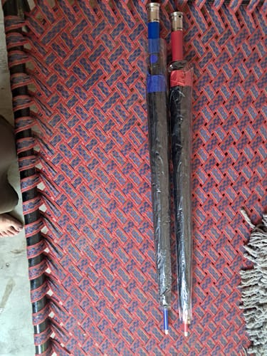 Customer's two folded UV Protected Umbrellas, one with a blue handle and one with a red, in original packaging.