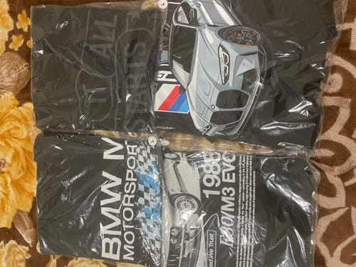 Customer shows four different black graphic Mystery Tees laid out in their original packaging.