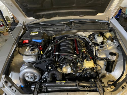 Customer's black Active 2 Stage Oil Catch Can installed in a car's clean engine bay.