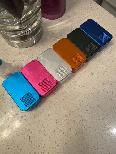 Reviewer's six colorful MagNano Cases lined up in a row on a speckled countertop.