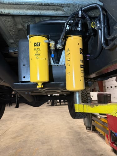 Customer's SPE Motorsport Fuel Filter System installed under a truck, with two yellow CAT filters visible.