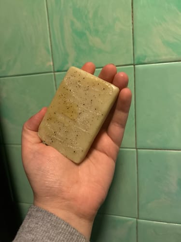 Reviewer holding a finished, speckled bar of soap made from the Mystery Box kit.