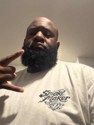 Reviewer in a close-up photo wearing the light-colored SMOKE MAKER TEE.