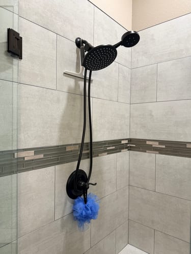 Customer's oil rubbed bronze 3-Spray Dual Shower Head Set installed in a modern tiled shower.