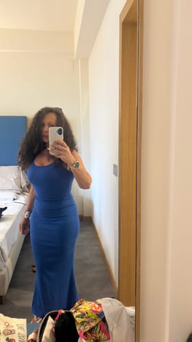 Reviewer takes a mirror selfie wearing the long, blue Slip Maxi Shapewear Dress, showing its form-fitting silhouette.