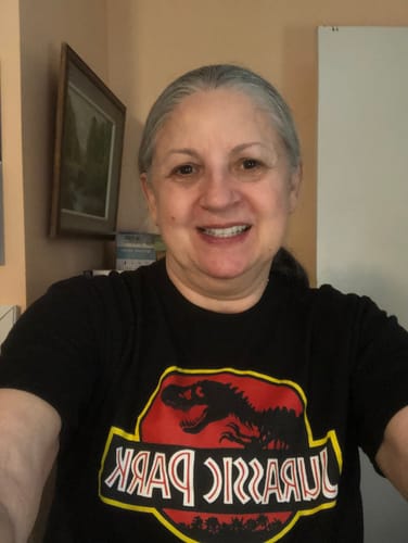 Reviewer smiling while wearing a black t-shirt with the Jurassic Park logo from the wholesale pack.