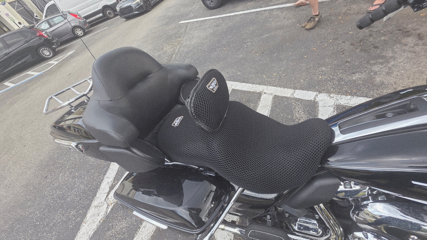 Wind Rider 3D mesh motorcycle seat cover fitted on a Harley touring bagger seat and passenger backrest, parked outdoors