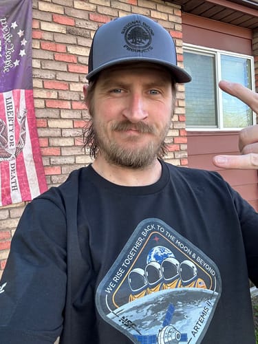 Reviewer wearing the black Artemis II unisex t-shirt with a large mission patch graphic on the chest.