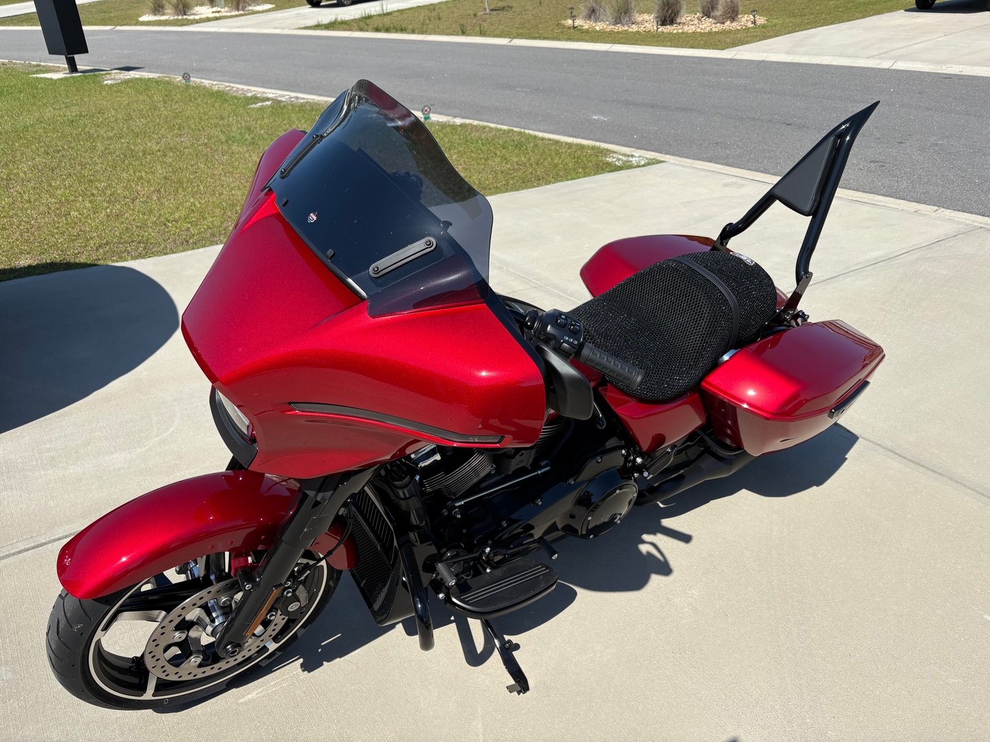 Mesh motorcycle seat cover installed on Harley bagger seat showing raised 3D airflow gap in shaded lot