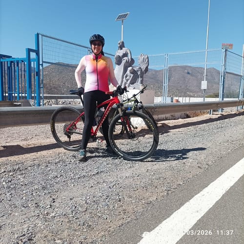 Clienta usando las calzas largas térmicas negras en una ruta de ciclismo al aire libre.