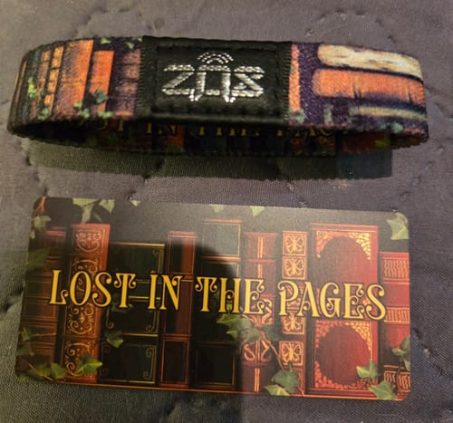 Customer's Lost In The Pages Bracelet showing the colorful bookshelf exterior next to its matching card.