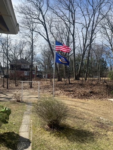 Customer's Heavy Duty American Nylon Flag flying on a flagpole in their yard.