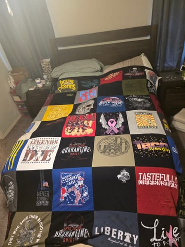 Customer's colorful Project Repat T-Shirt Quilt made of various shirts spread across a bed.
