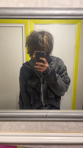 Reviewer in a mirror selfie wearing the dark grey, cropped Personsoul Sand Dirty Dye Zip-Up Hoodie.