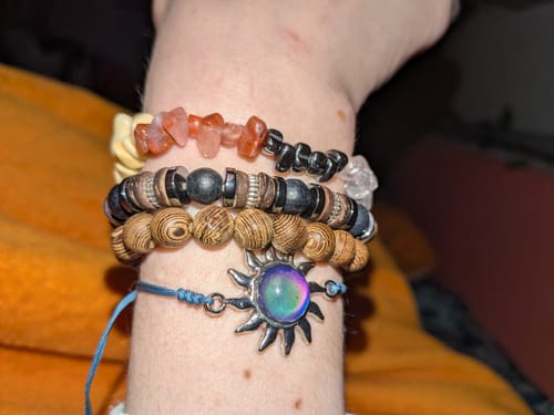 Rezensent trägt das Chakra-Armband zusammen mit anderen Armbändern am Handgelenk.