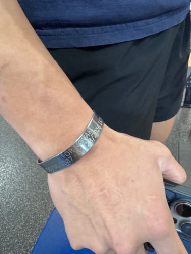 Close-up of a customer wearing the customized stainless steel bracelet with personal engraving on their wrist.
