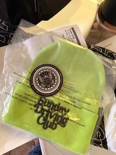 Customer's lime green SDC™ BEANIE in its clear packaging with a round sticker on top.